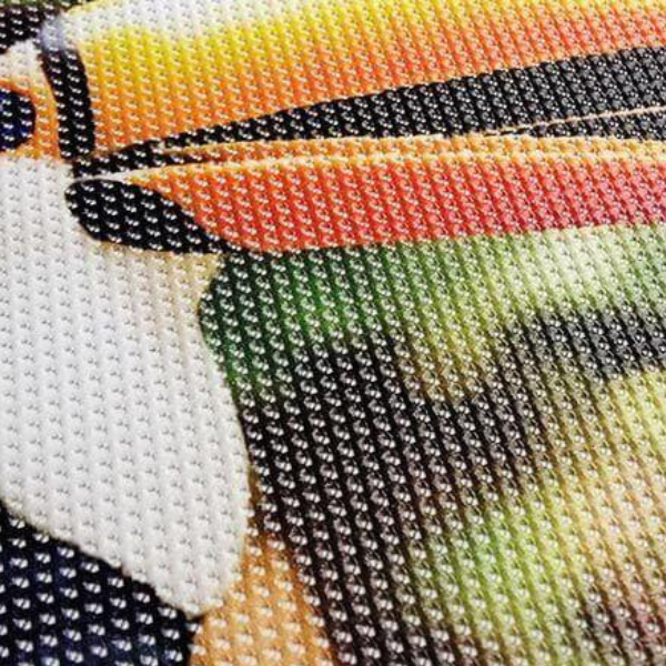 A durable mesh banner with holes, displaying vibrant graphics and text, suitable for outdoor use.