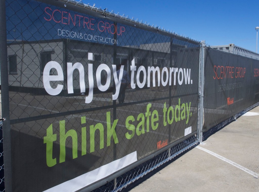 A colorful custom banner displayed at an outdoor event, showcasing vibrant graphics and bold text.